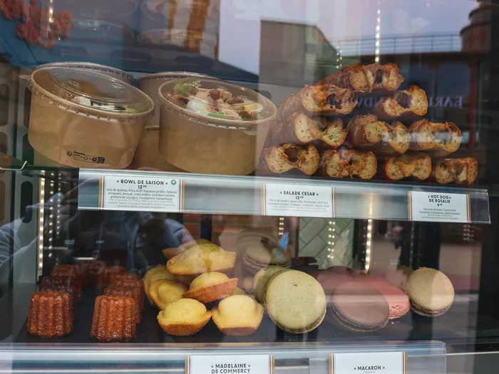 Vitrine du Comptoir avec bowls, bagels, canelés, madeleines et macarons alignés sur les étagères.