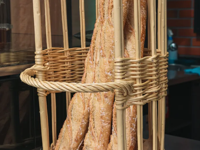 Grand panier en osier garni de baguettes fraîches posé sur le comptoir du restaurant Le Comptoir.