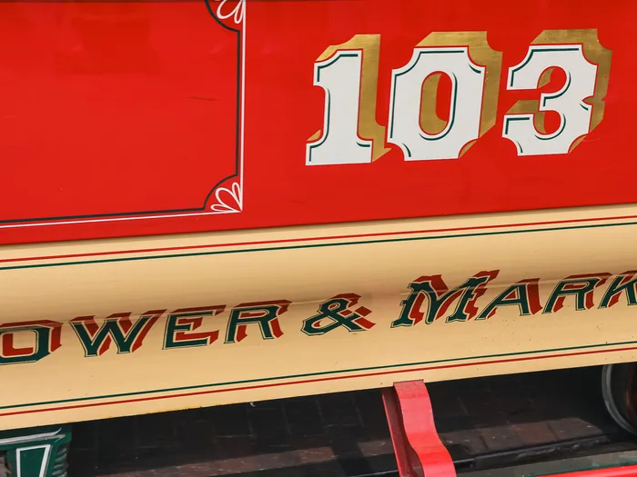 Flanc rouge et crème d’un tramway hippomobile orné du numéro 103 et de l’inscription « Flower & Market ».