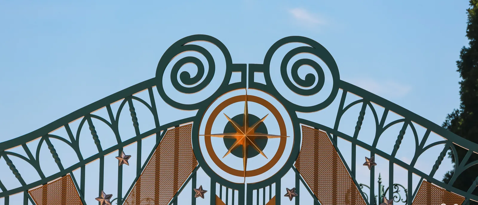 Sommet des grilles d’entrée de Disneyland Paris orné d’oreilles de Mickey et d’une rose des vents