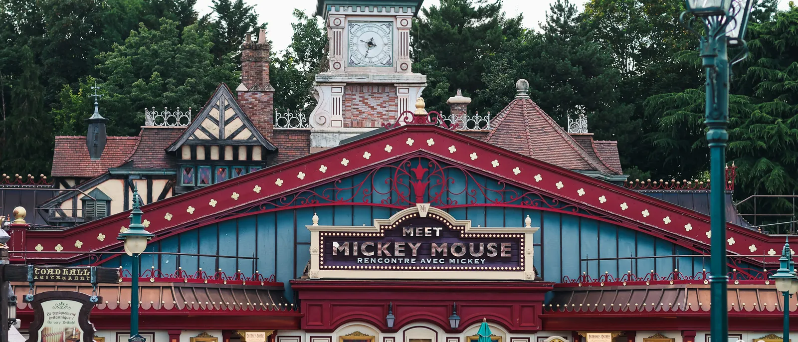 La façade victorienne du Meet Mickey Mouse à Fantasyland, avec son enseigne et son horloge à clocheton.