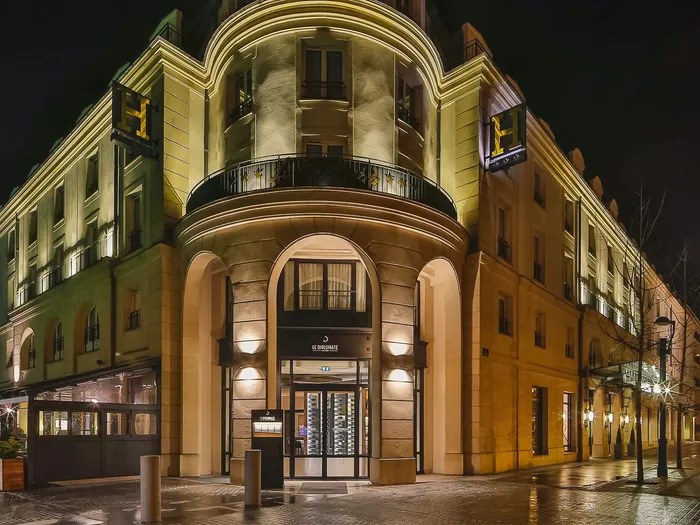 Façade en pierre de l’hôtel Val d’Europe illuminée la nuit près de Disneyland Paris