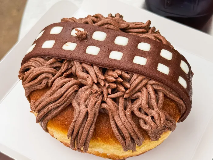 Beignet décoré aux couleurs de Chewbacca posé sur une assiette, à Cool Station dans Discoveryland.