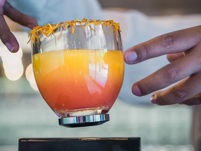 Cocktail orangé garni de zeste servi au bar du Bleecker Street Lounge