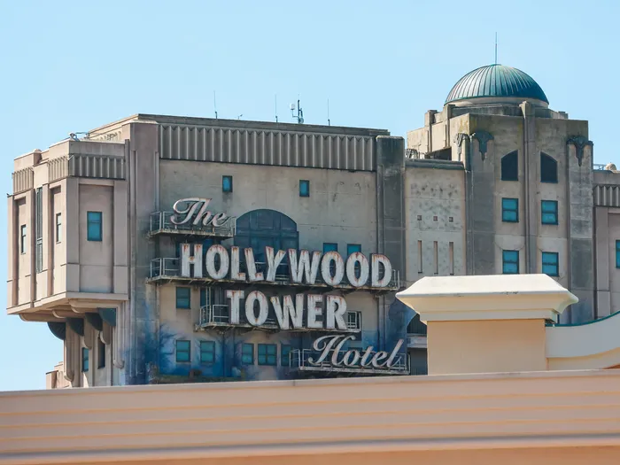 Façade du Hollywood Tower Hotel dépassant des toits de World Premiere Plaza, au Parc Disney Adventure World.