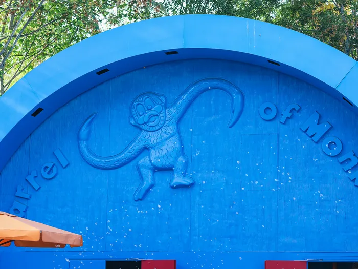 Rounded blue frontage of the Toy Story Playland shop at Disneyland Paris, with the raised monkey and the Barrel of Monkeys sign above the entrance.