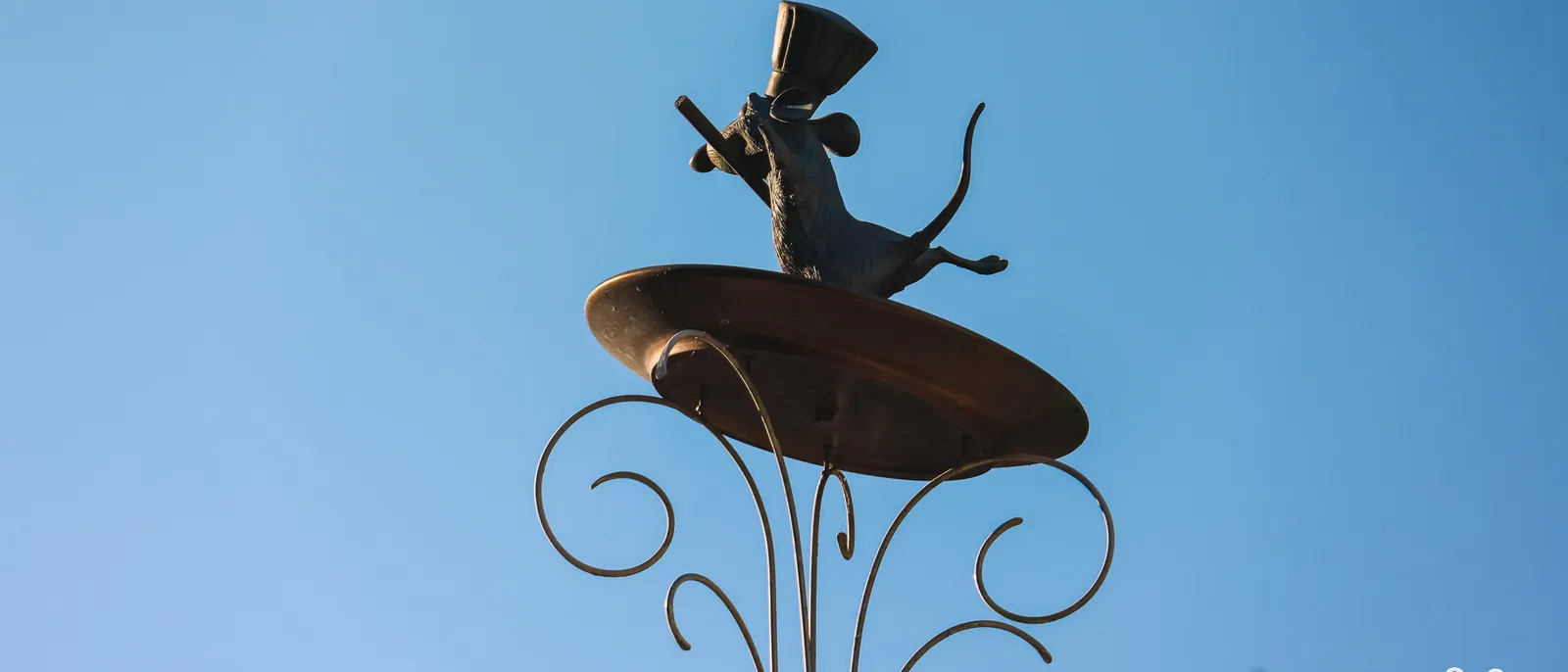 Statue en bronze de Rémy le rat, coiffé d’une toque et un fouet à la main, sur une assiette, à Worlds of Pixar.