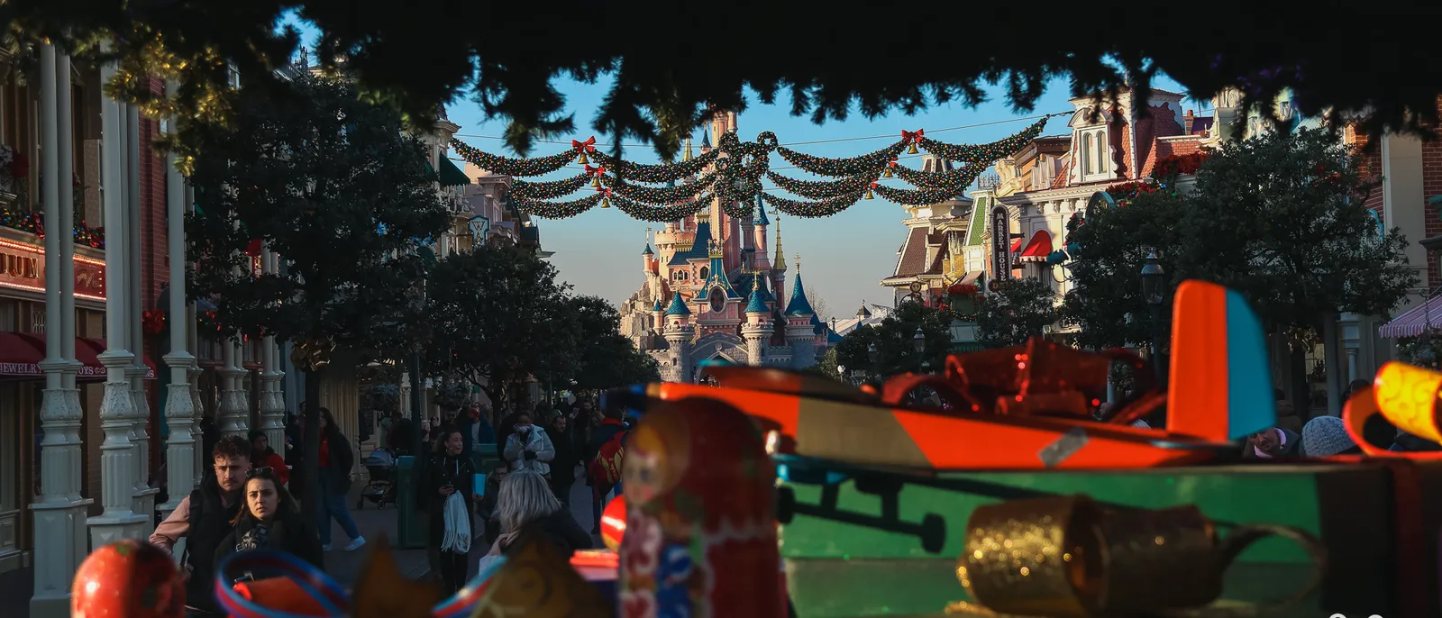 Main Street U.S.A. ornée de guirlandes de Noël, le château rose en enfilade au lever du jour à Disneyland Paris.