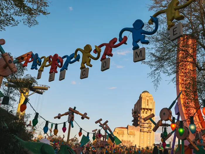 Enseigne Welcome portée par des singes au-dessus de Toy Story Playland, Tower of Terror au crépuscule.