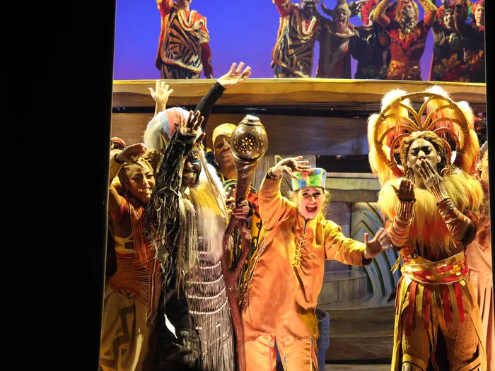 Troupe en costumes africains colorés lors du final du spectacle Le Roi Lion à Disneyland Paris