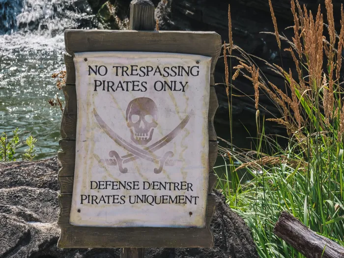 Panneau de pirate « No Trespassing Pirates Only / Défense d’entrer » devant une cascade à Adventure Isle