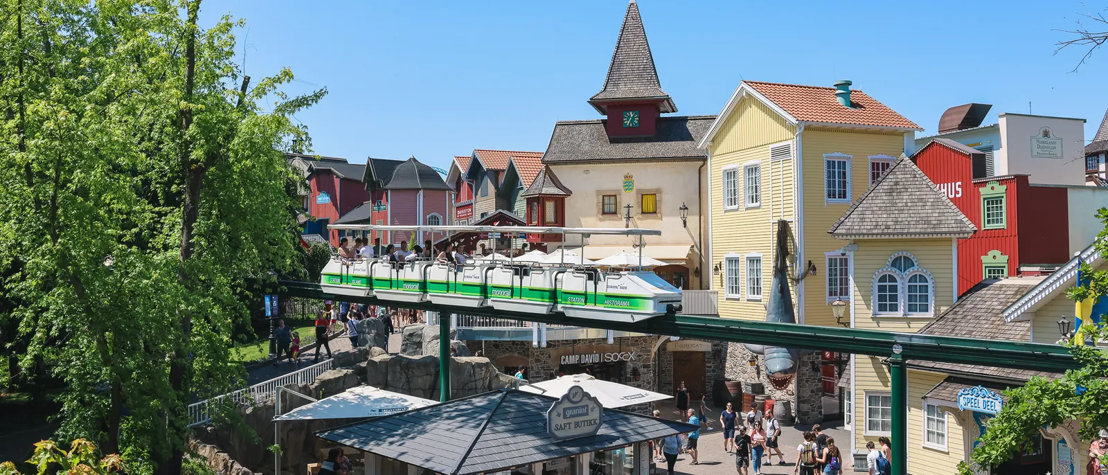 Le monorail vert traverse une place bordée de maisons colorées, vue en hauteur, à Europa-Park
