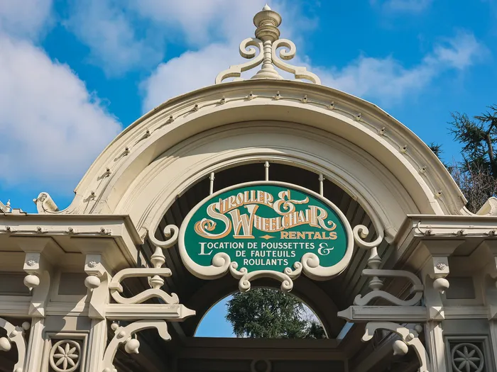 Bilingual "Stroller & Wheelchair Rentals" sign for pushchair and wheelchair hire at Disneyland Paris.