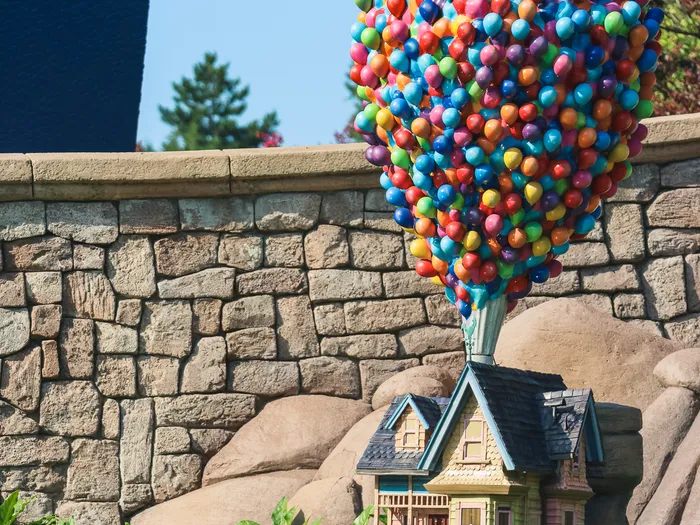 Miniature de la maison du film Là-Haut portée par une grappe de ballons colorés au Pays des Contes de Fées à Fantasyland