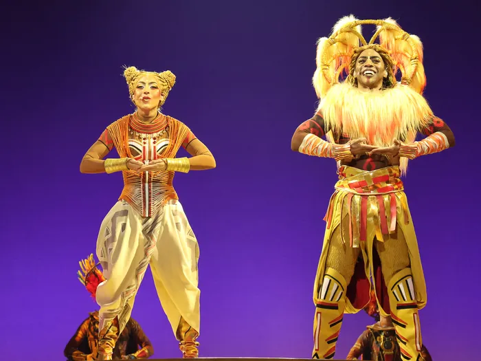 Deux artistes en costumes de Simba et lionne dansent sur scène violette lors du spectacle Le Roi Lion à Disneyland Paris.