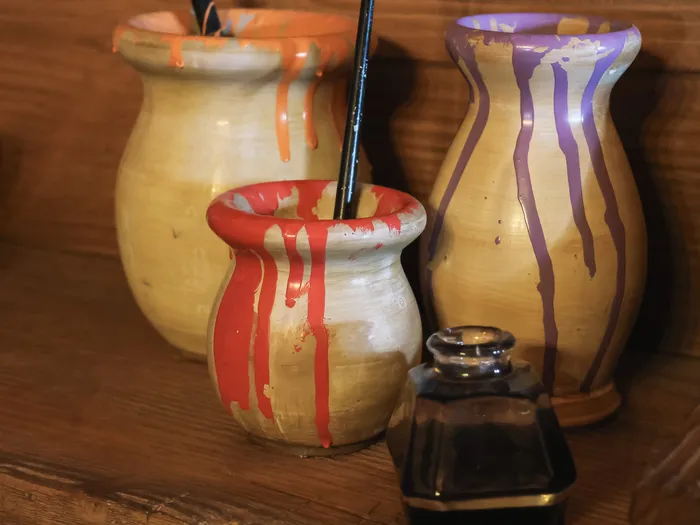 Pots en céramique dégoulinant de peinture colorée et pinceau, décor de l’attraction Les Voyages de Pinocchio