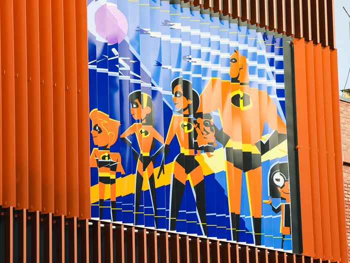 Fresque des super-héros Indestructibles en costumes orange sur la façade de la boutique Disney Style