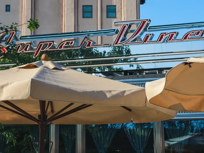 Enseigne néon « Super Diner » surplombant les parasols de la terrasse du restaurant Super Diner