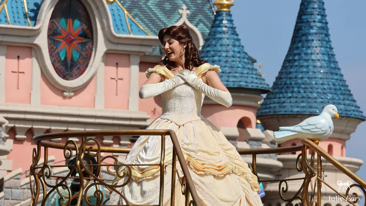 Princesse Belle en robe jaune sur scène devant le château de la Belle au Bois Dormant, colombe blanche