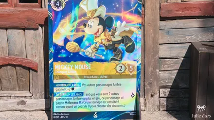 Giant Disney Lorcana card of Mickey Mouse, Amber Champion, displayed on a wooden board at Disneyland Paris