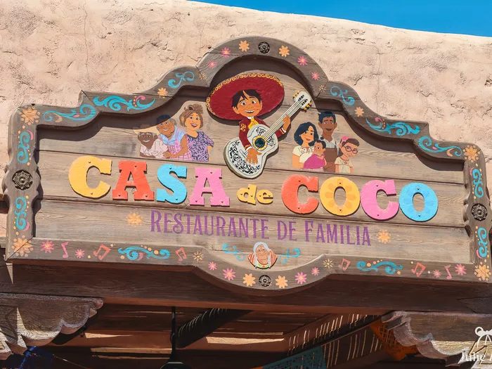 Enseigne en bois sculpté de Casa de Coco avec Miguel et sa guitare et les personnages du film, à Frontierland.